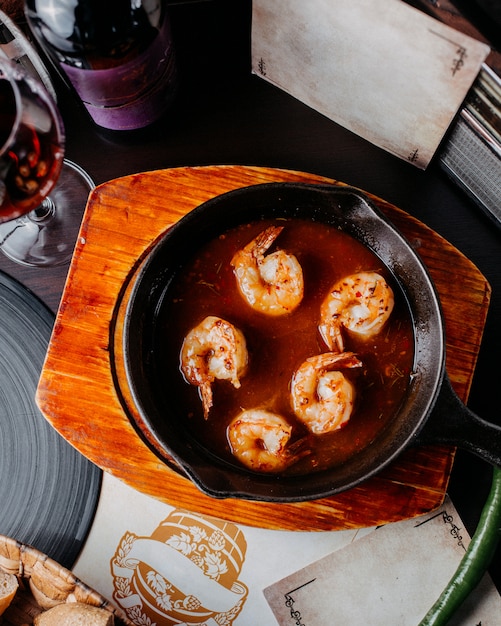 Gratis foto bovenaanzicht van gebakken garnalen met saus op een zwarte pan