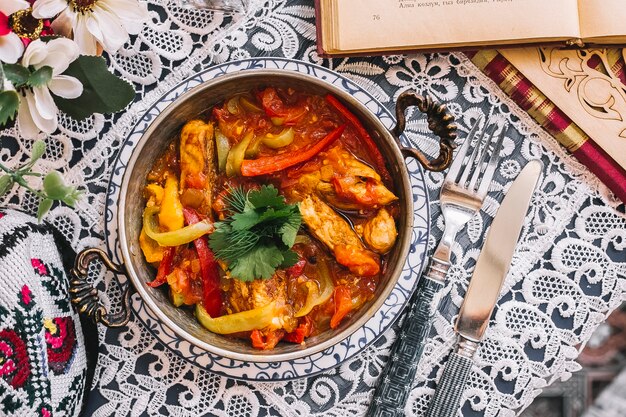 Bovenaanzicht van gebakken kip met rode en groene paprika