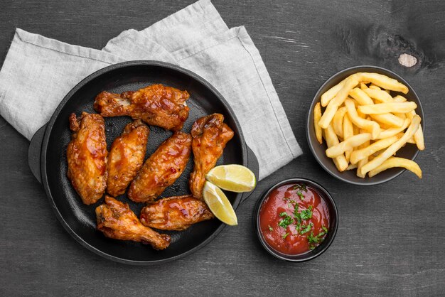 Bovenaanzicht van gebakken kip met saus en frietjes