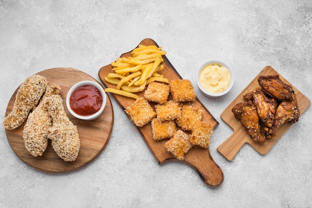 Bovenaanzicht van gebakken kipnuggets en sauzen op snijplanken