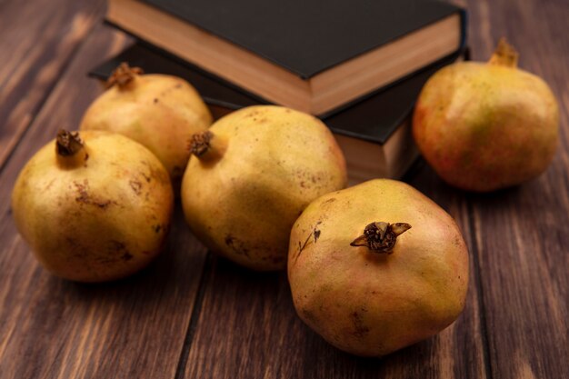 Bovenaanzicht van geelachtig roze granaatappels met schil geïsoleerd op een houten oppervlak