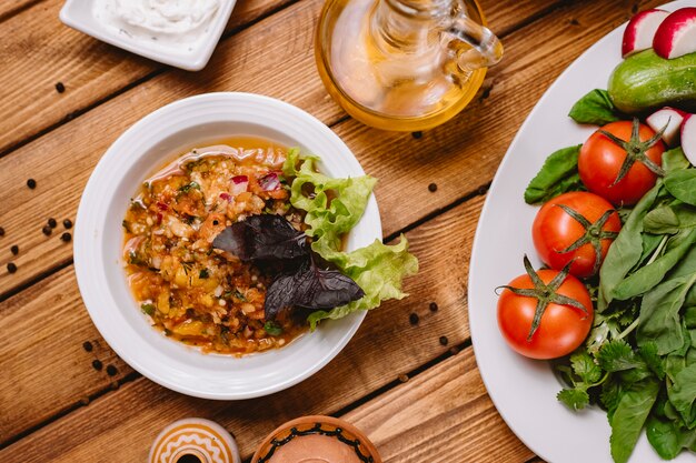 Bovenaanzicht van gegrilde auberginesalade met tomaten, paprika, ui en kruiden