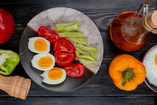 Bovenaanzicht van gekookte gehalveerde eieren op een plaat met paprika met appelazijn op een houten achtergrond