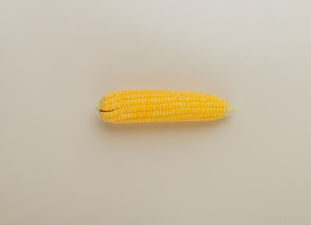 Bovenaanzicht van gekookte maïs op witte ondergrond met kopie ruimte