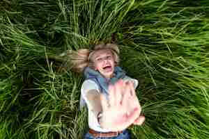 Gratis foto bovenaanzicht van gelukkige vrouw poseren in gras