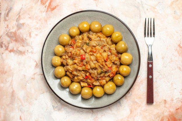 Gratis foto bovenaanzicht van geroosterde auberginesalade en ingelegde pruimen op plaatvork op naakt oppervlak