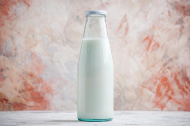 Bovenaanzicht van gesloten glazen fles gevuld met melk op pastelkleuren oppervlak