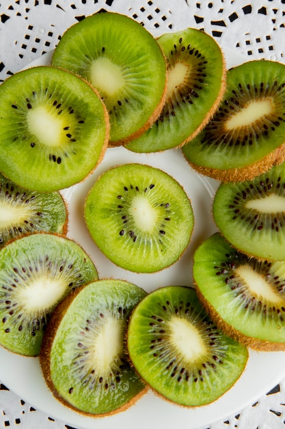 Gratis foto bovenaanzicht van gesneden kiwi's op papier kleedje oppervlak