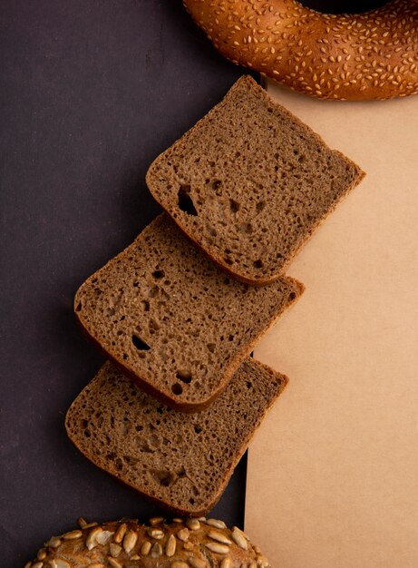 Bovenaanzicht van gesneden roggebrood op kastanjebruine achtergrond met kopie ruimte