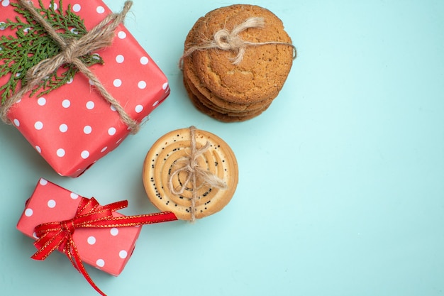 Bovenaanzicht van gestapelde verschillende heerlijke koekjes rode geschenkdozen op pastelgroene achtergrond