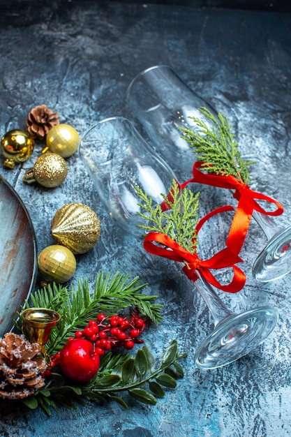 Bovenaanzicht van gevallen glazen bekers met rood lint dennentakken decoratie accessoires op donkere achtergrond