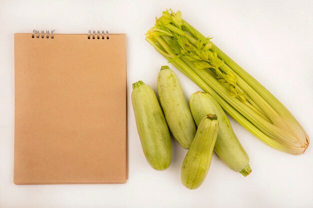 Bovenaanzicht van gezonde groenten zoals selderij en courgettes geïsoleerd op een witte achtergrond met kopie ruimte