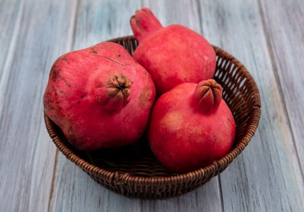 Bovenaanzicht van gezonde rossige granaatappels op een emmer op een grijze achtergrond