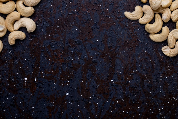 Bovenaanzicht van gezouten geroosterde pistachenoten op zwarte achtergrond met kopie ruimte