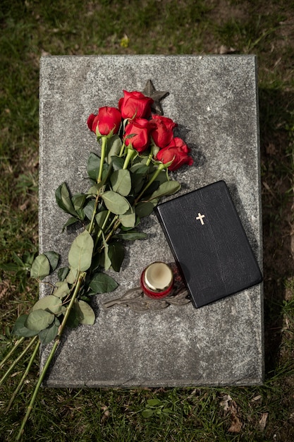 Bovenaanzicht van grafsteen met bloemen en kaars