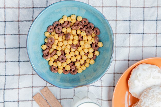 Bovenaanzicht van granen in kom met peperkoekjes melk koekjes op geruite doek