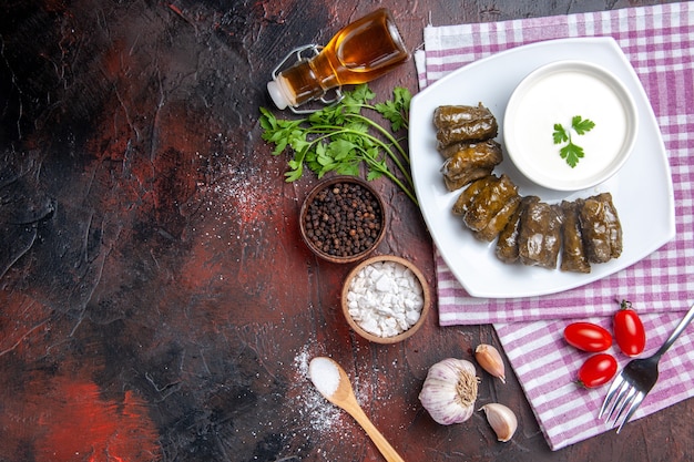 Gratis foto bovenaanzicht van groene blad dolma met yoghurt op het donkere oppervlak