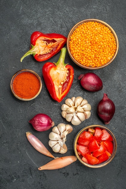 Bovenaanzicht van groenten kom linzen tomaten kruiden paprika knoflook ui