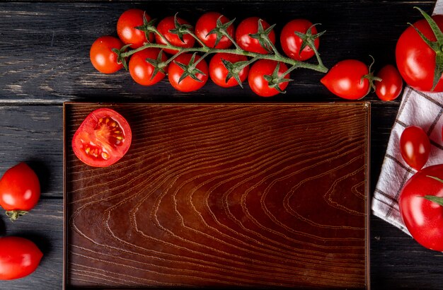 Bovenaanzicht van half gesneden tomaat in lade en hele degenen op hout