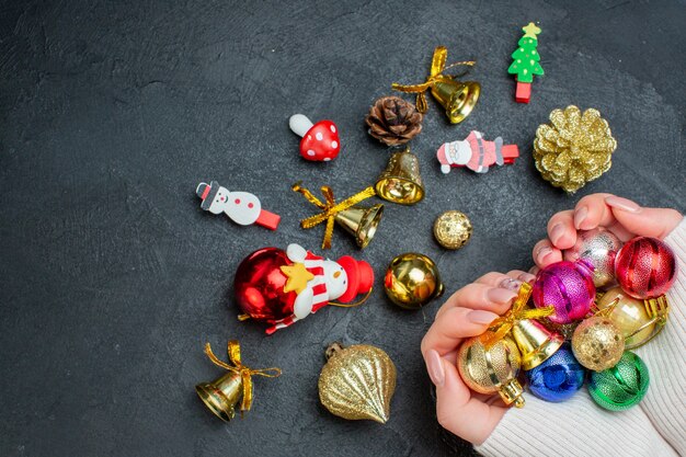 Bovenaanzicht van hand met kleurrijke decoratie accessoires op donkere achtergrond