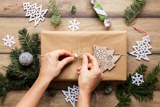 Gratis foto bovenaanzicht van handen op kerstcadeau