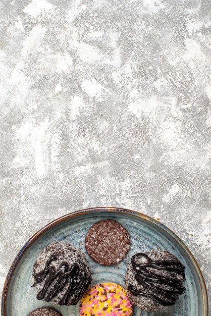 Bovenaanzicht van heerlijke chocolade ballen taarten met koekjes op witte ondergrond Gratis Foto