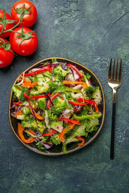Bovenaanzicht van heerlijke groentesalade met verschillende ingrediënten op zwarte snijplank