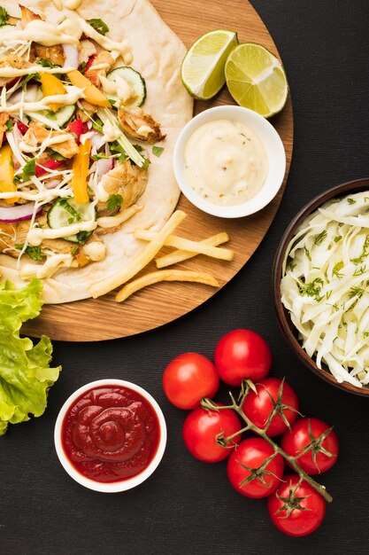 Bovenaanzicht van heerlijke kebab met tomaten en limoenen (lemmetjes)