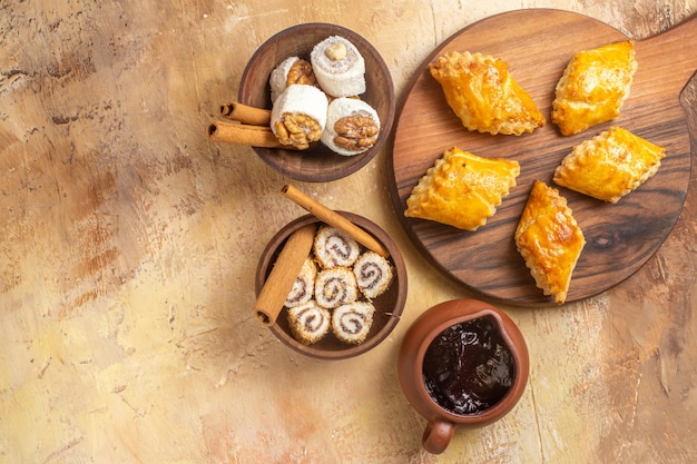 Bovenaanzicht van heerlijke notencake met confitures op houten oppervlak