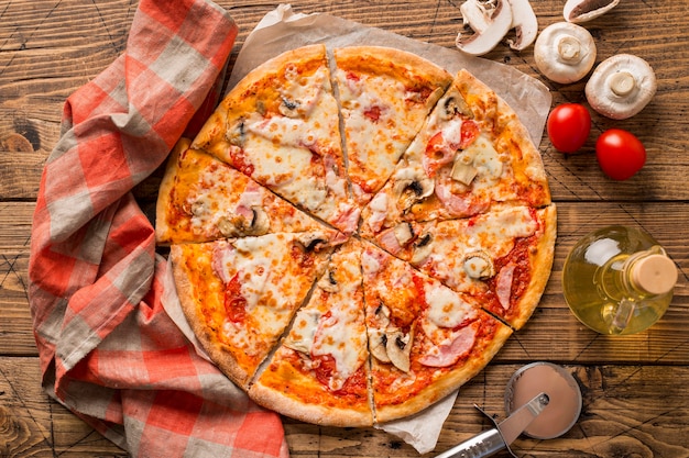 Bovenaanzicht van heerlijke pizza op houten tafel