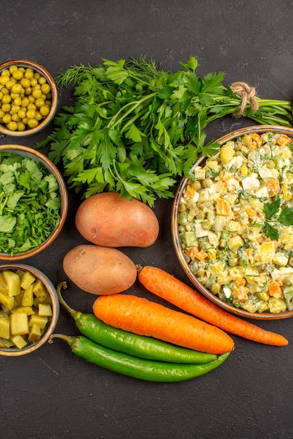 Gratis foto bovenaanzicht van heerlijke salade met verse groenten op donkere ondergrond