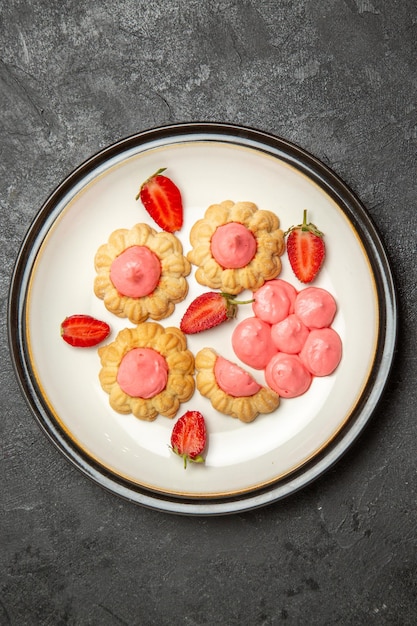 Bovenaanzicht van heerlijke suikerkoekjes met aardbeigelei op grijze ondergrond