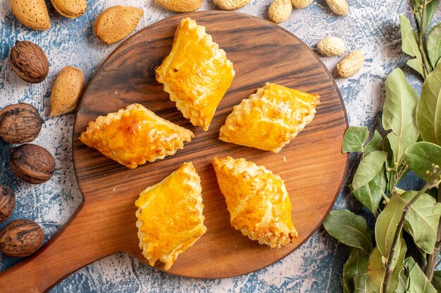 Bovenaanzicht van heerlijke zoete gebakjes met noten op blauwe ondergrond