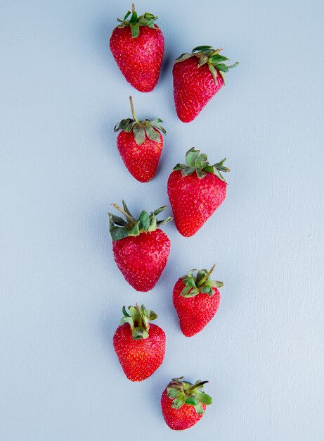 Bovenaanzicht van hele aardbeien op blauwe ondergrond