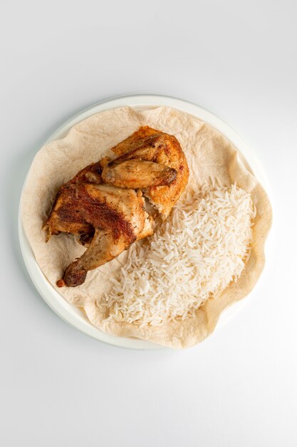 Bovenaanzicht van hele gegrilde kip en rijst geserveerd op flatbread