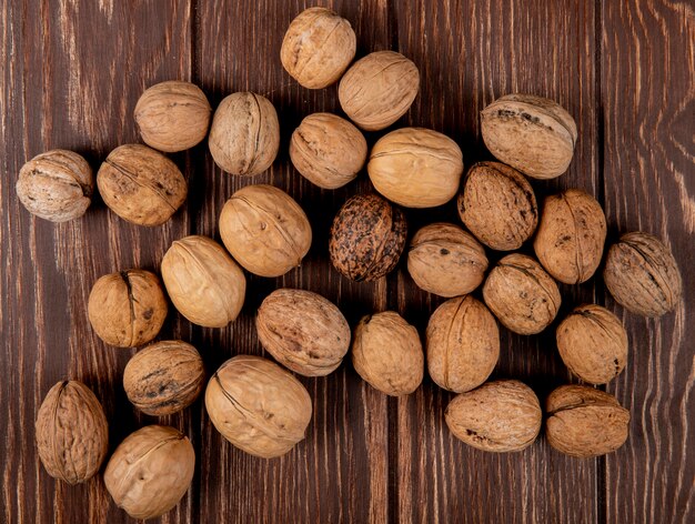 Bovenaanzicht van hele walnoten verspreid over houten achtergrond