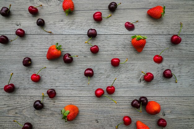 Bovenaanzicht van houten achtergrond met kersen en aardbeien