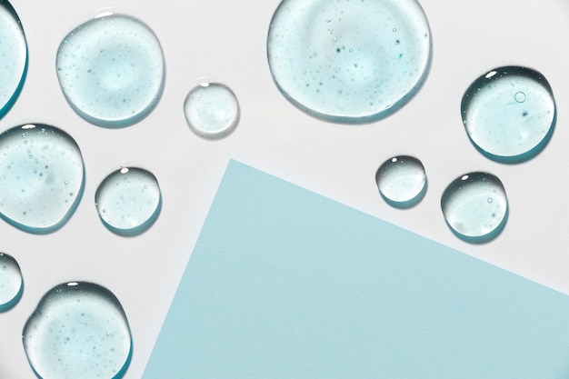 Gratis foto bovenaanzicht van hydro-alcoholische gel druppels met papier