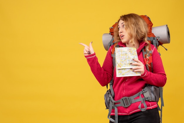 Gratis foto bovenaanzicht van jong verrast reizend meisje in medisch masker dat haar bagage verzamelt en kaart naar achteren houdt
