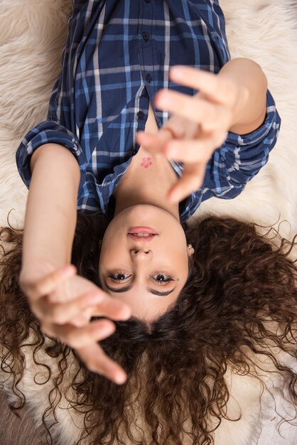 Bovenaanzicht van jonge vrouw die op tapijt ligt