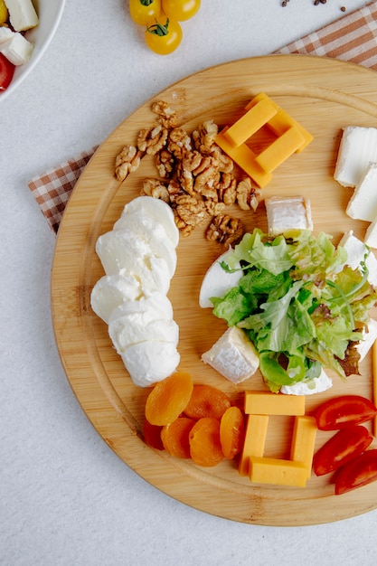 Bovenaanzicht van kaas plaat met noten op een tafel