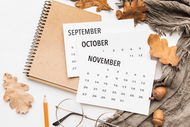 Gratis foto bovenaanzicht van kalender met bril en herfstbladeren