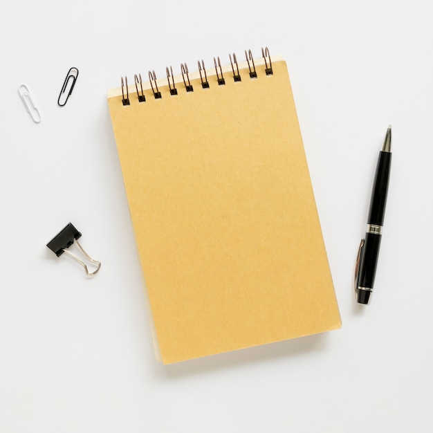 Bovenaanzicht van kantoorbenodigdheden met notebook en pen