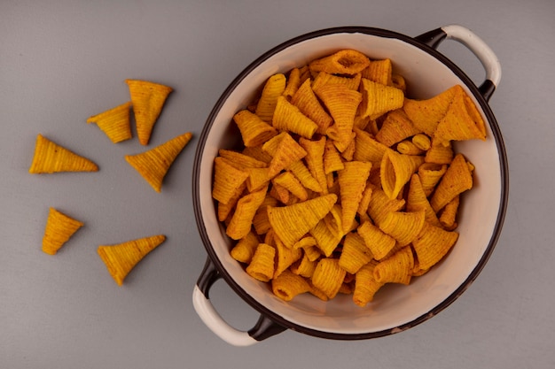 Bovenaanzicht van kegelvorm gebakken maïs snacks op een kom