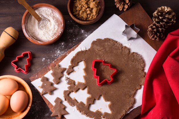 Bovenaanzicht van kerstkoekjesdeeg met kerstboomvormen