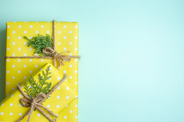 Bovenaanzicht van Kerstmis achtergrond met gele geschenkdozen op pastel groene achtergrond