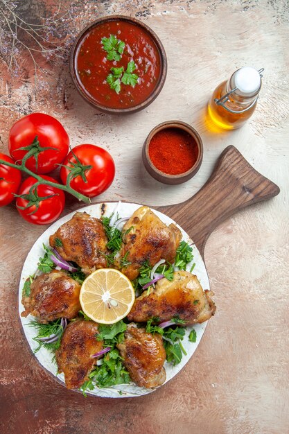 Bovenaanzicht van kip bord met de kip met citroen kruiden tomaten saus kruiden olie