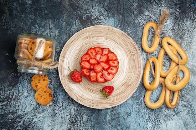 Bovenaanzicht van kleine fruitige cake met crackers op donkere ondergrond