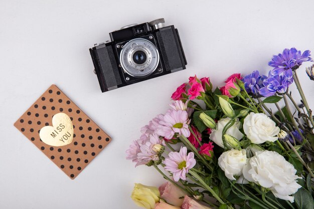 Bovenaanzicht van kleurrijke en verbazingwekkende bloemen zoals rozen en madeliefjebloemen met camera op een witte achtergrond