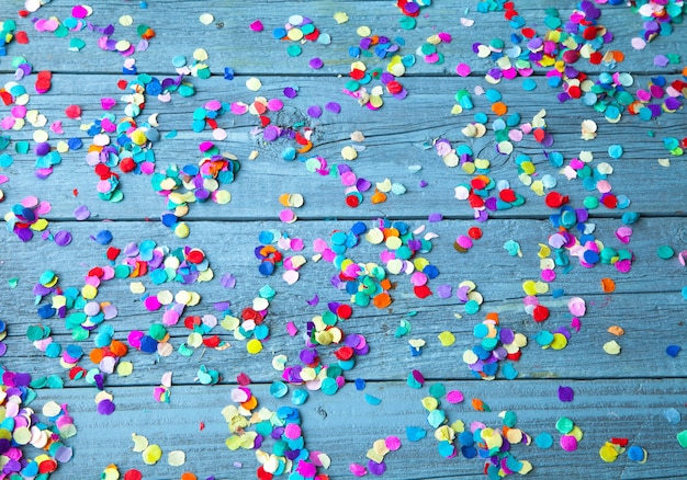 Bovenaanzicht van kleurrijke ronde confetti op een lichtblauwe houten achtergrond Gratis Foto